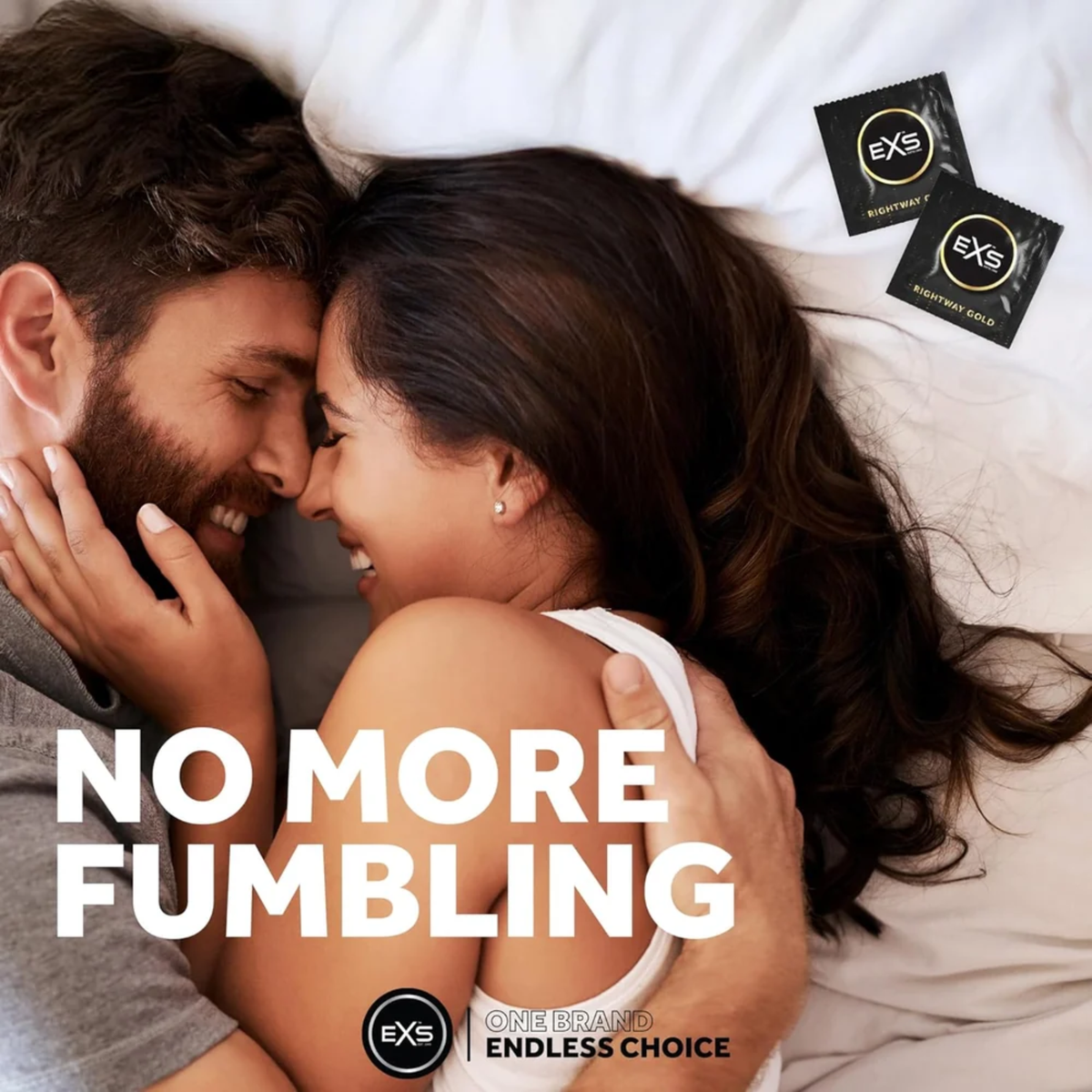 Lifestyle image of a smiling couple embracing closely in bed. Bold text overlay reads "NO MORE FUMBLING," accompanied by two black and gold EXS Rightway Gold condom wrappers in the upper corner.