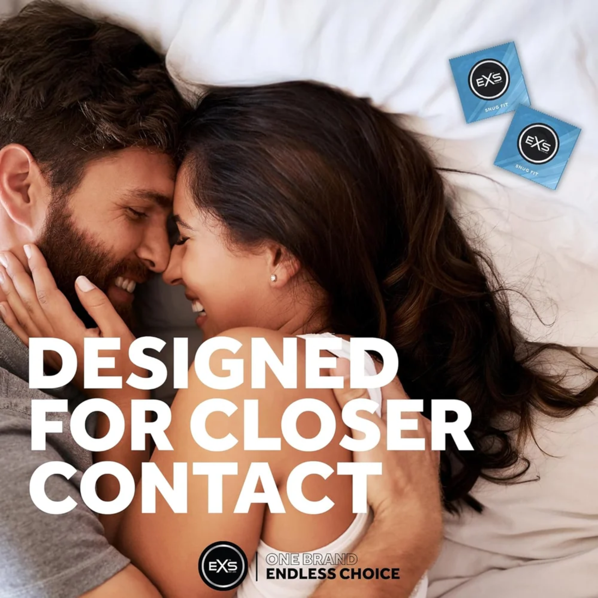 Lifestyle image of a smiling couple embracing closely in bed. Bold text overlay reads "DESIGNED FOR CLOSER CONTACT," accompanied by two blue EXS Snug Fit condom wrappers in the upper corner.