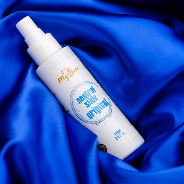 The 100 ml bottle of MyLove Neutral Slide Original lubricant rests at an angle on rich, draped royal blue satin fabric.