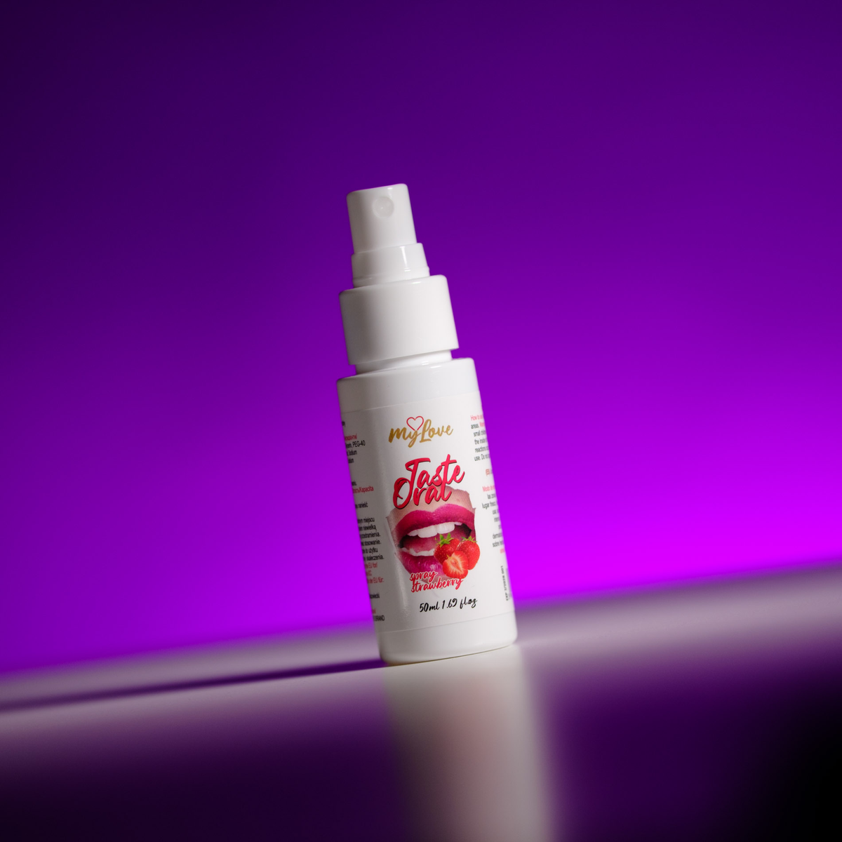 Front view of the 50 ml MyLove Taste Oral Spray bottle, angled slightly on a white surface against a vibrant purple backlit background.
