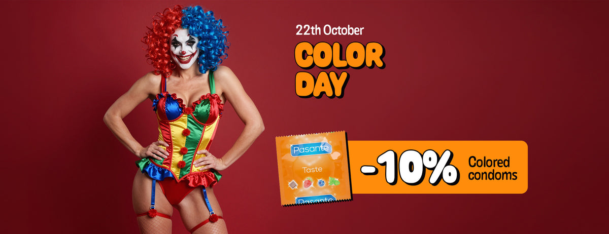 Wide promotional banner titled "22th October COLOR DAY" set against a deep red background, featuring a woman in colorful clown makeup, a split red-and-blue wig, and a multi-colored corset costume standing beside an orange Pasante Taste condom foil packet and an orange banner offering "-10% Colored condoms".